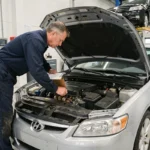 Mécanicien professionnel effectuant un contrôle technique sur une voiture dans un centre d'inspection automobile agréé